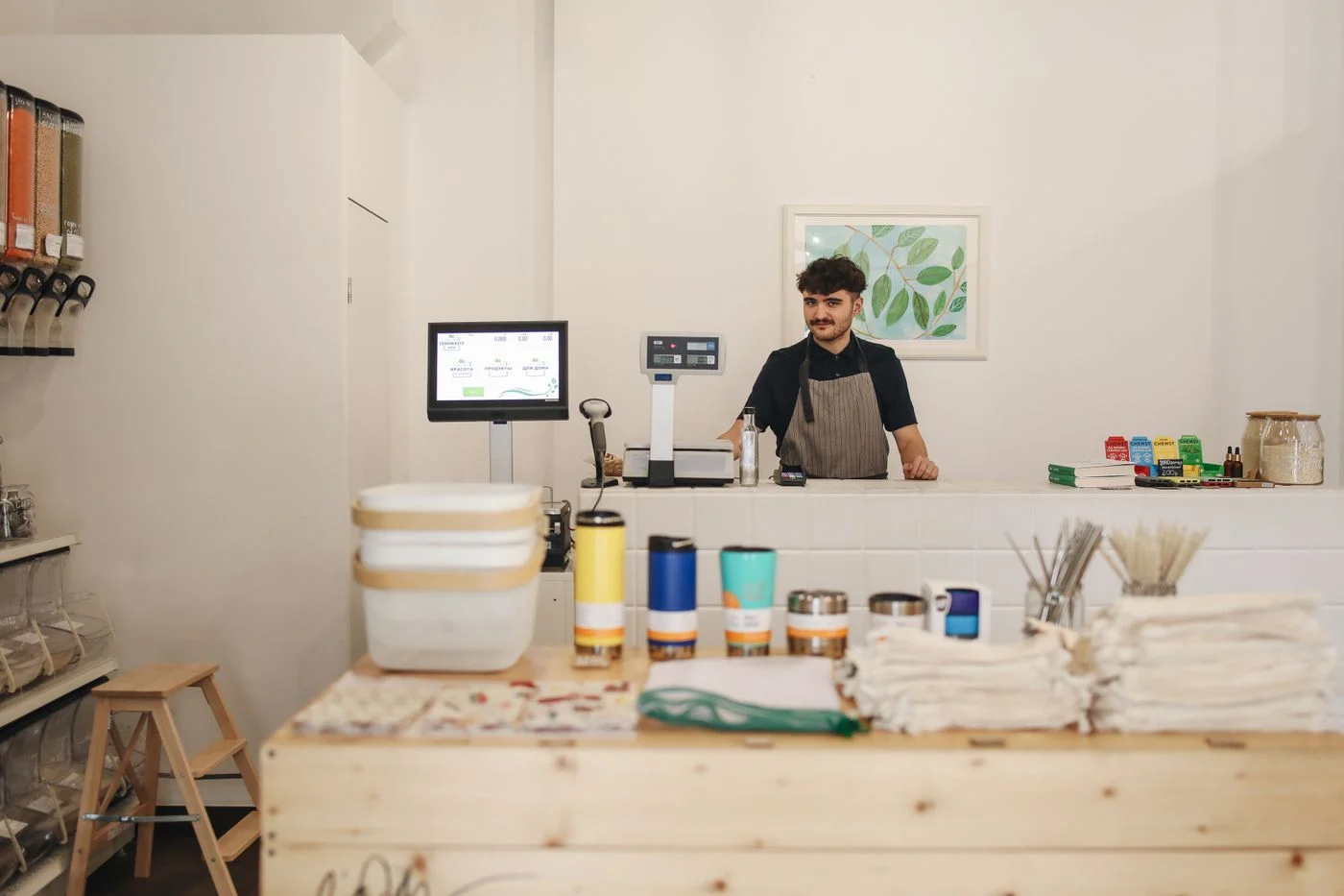 A small-business owner behind the counter of a cafe.